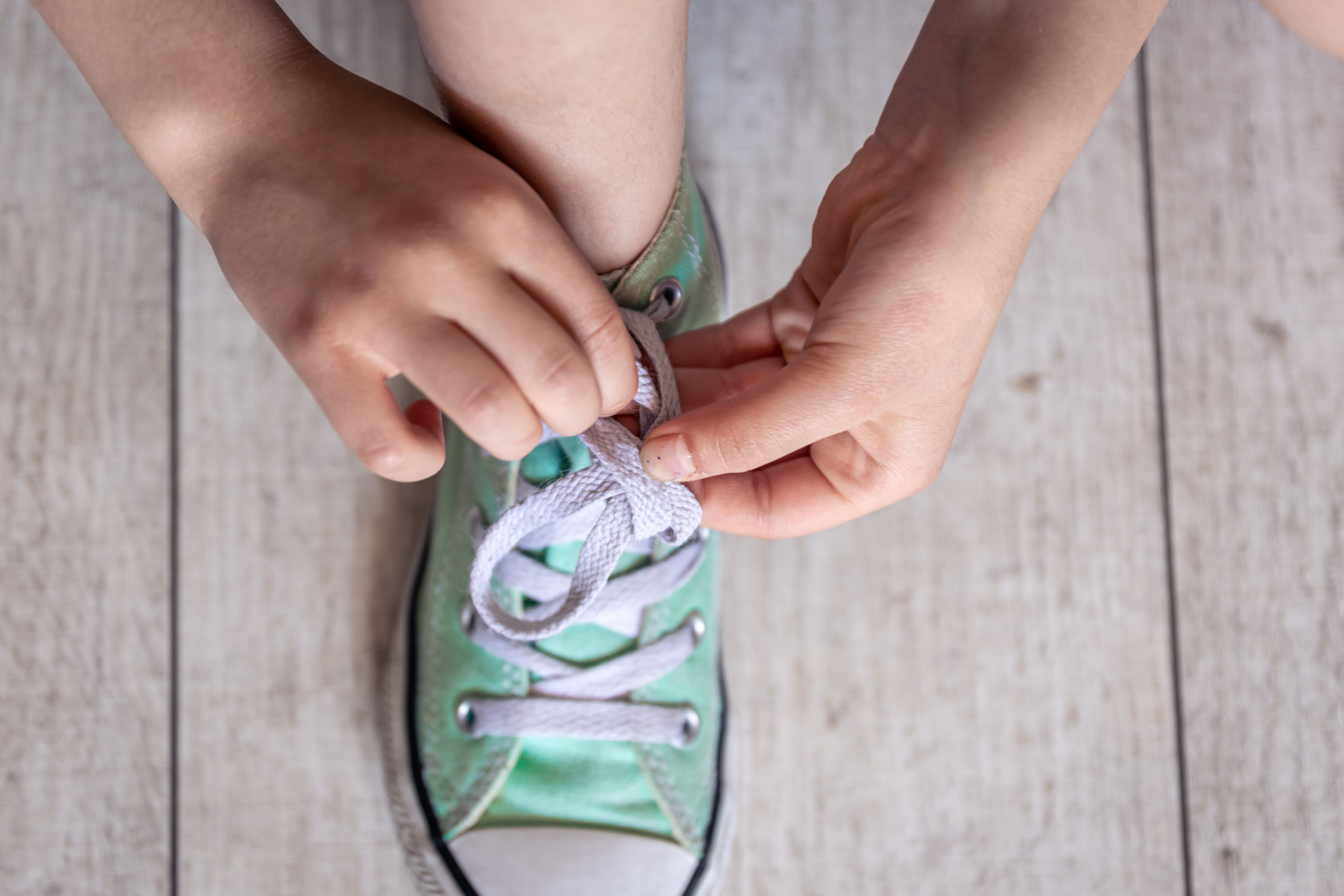 child-successfully-ties-shoes-close-up-feet.jpg